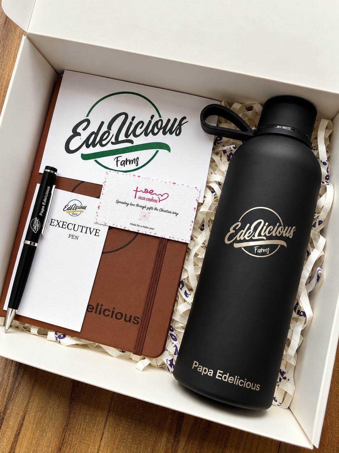 A customized journal, tumbler and pen with the edelicious logo