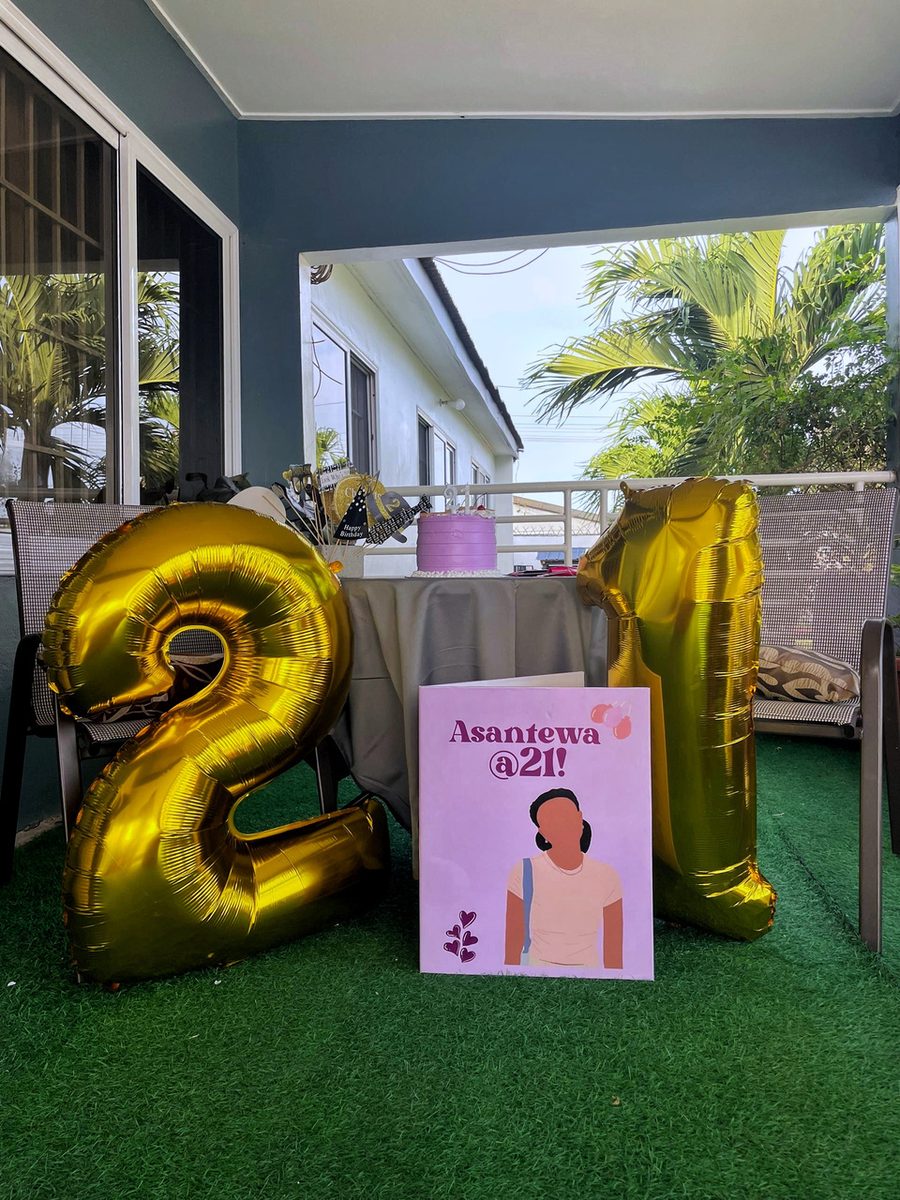 The Jumbo lifesize birthday card in lilac, displayed beside gold number balloons